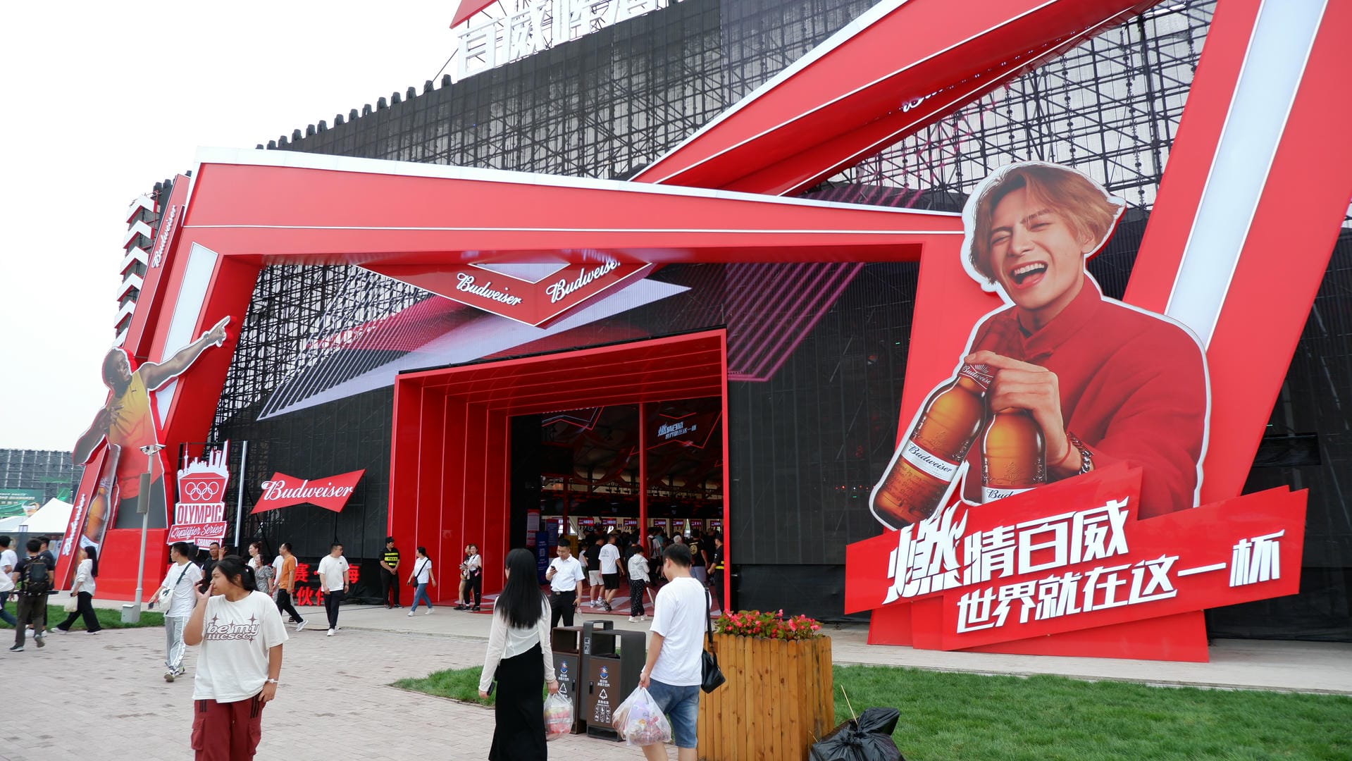 people walking around a building with a large advertisement on it