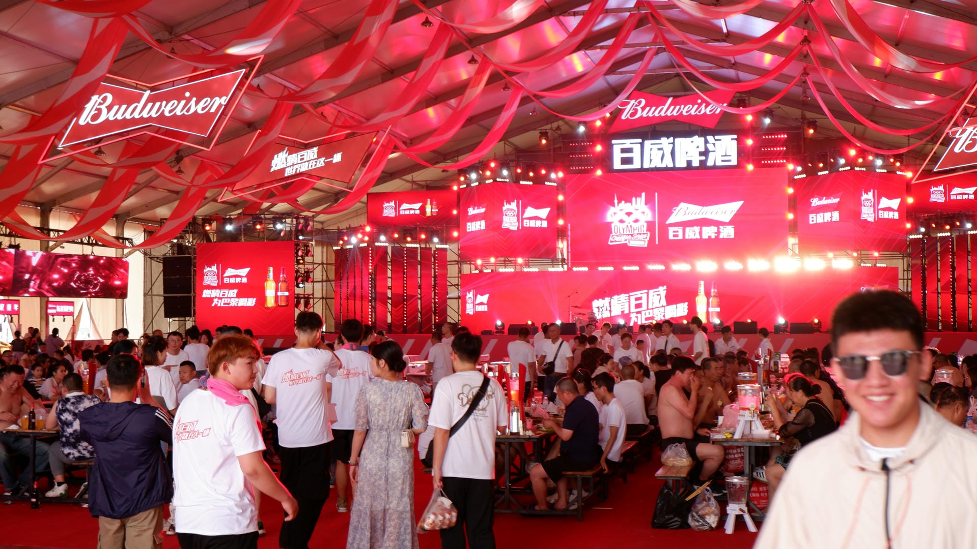people are standing in a large room with red banners and red lights