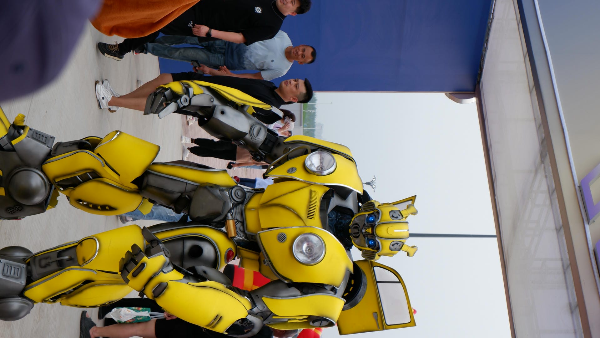 person dressed in a yellow and black costume standing in front of a crowd