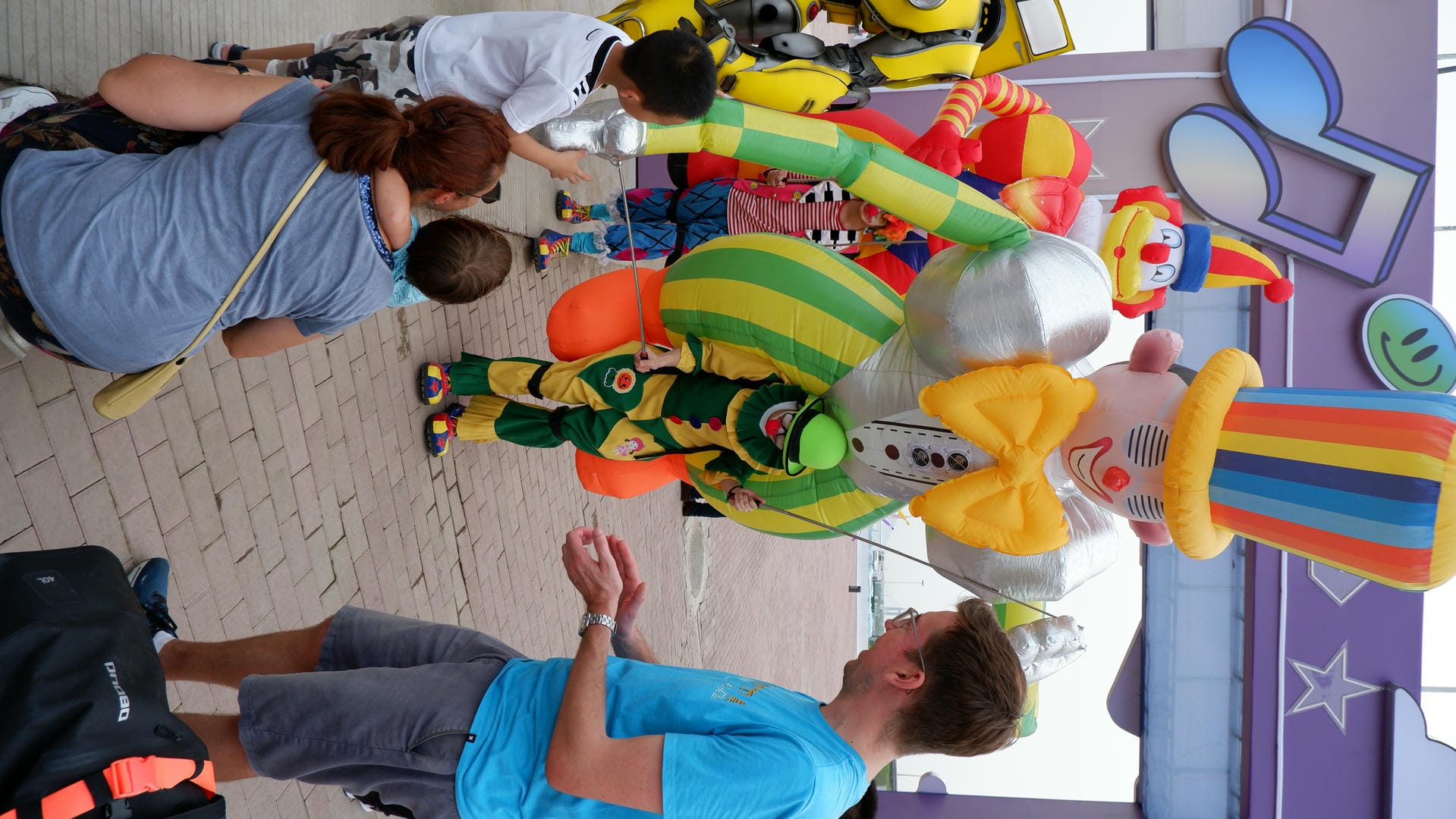 people are gathered around a clown balloon in a parade