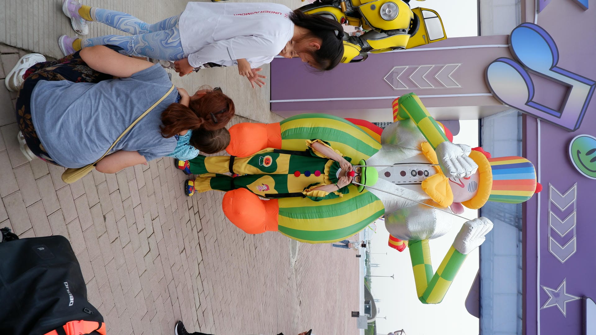 people are standing around a giant inflatable clown with a guitar