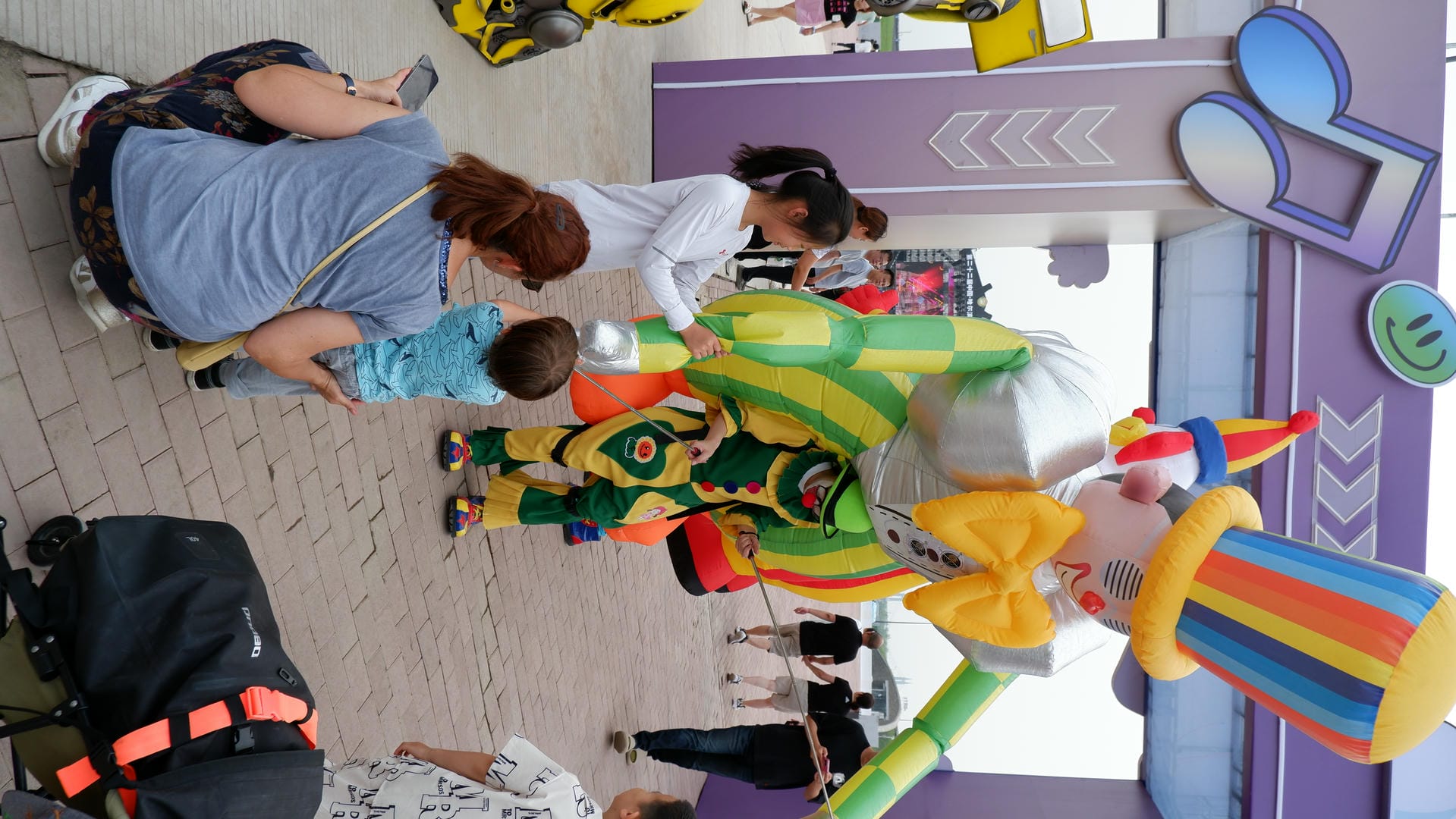 people are gathered around a large inflatable clown in a city