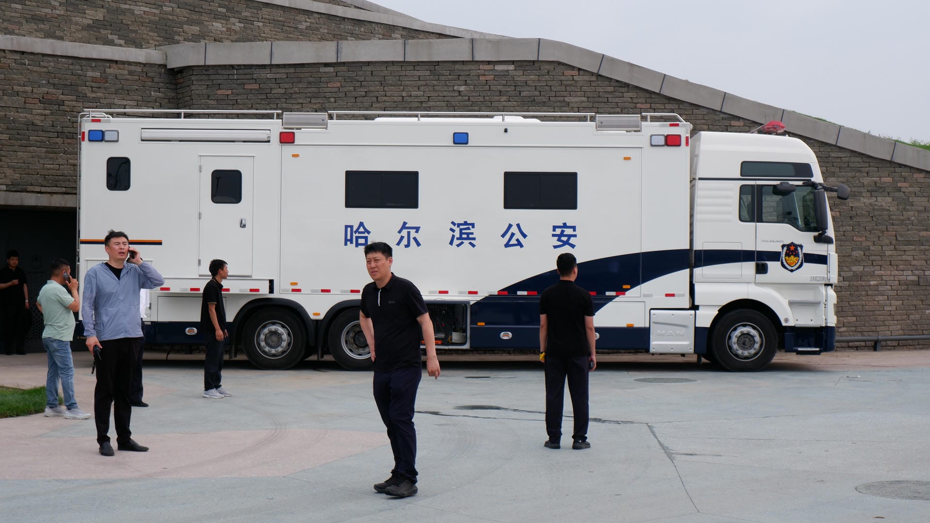 people standing in front of a white truck with chinese writing on it