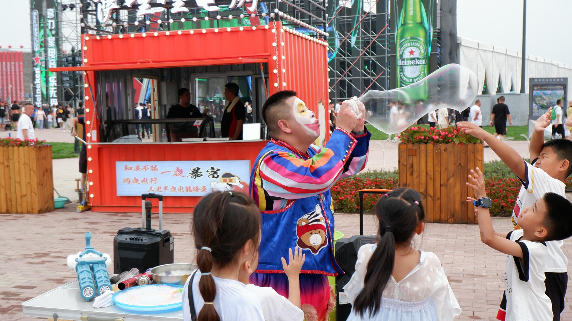 there are many children standing around a man pouring water on a bottle