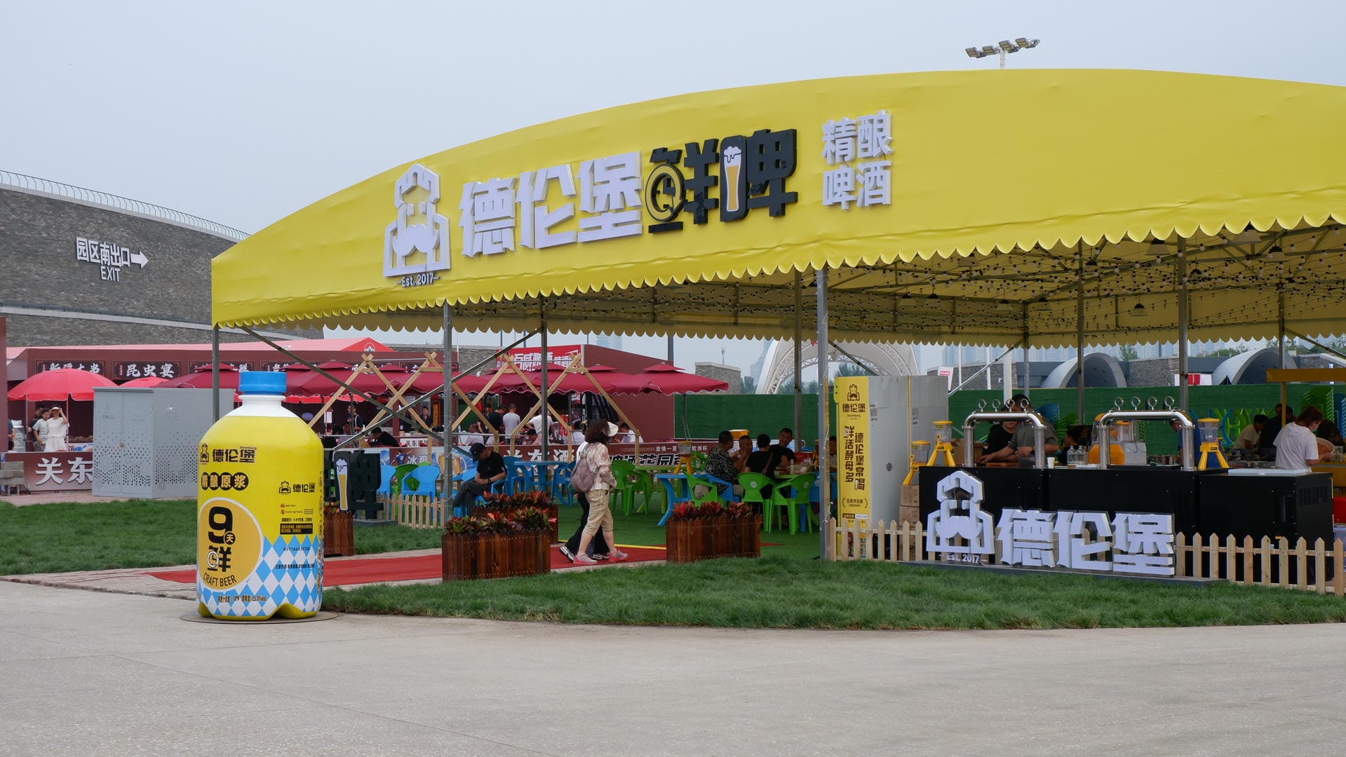 yellow tent with a sign that says sunflowers and people standing under it