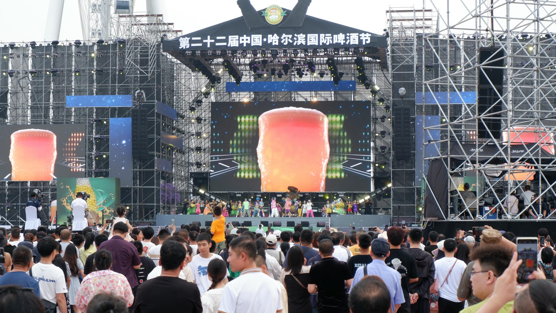 people are standing in front of a stage with a giant screen