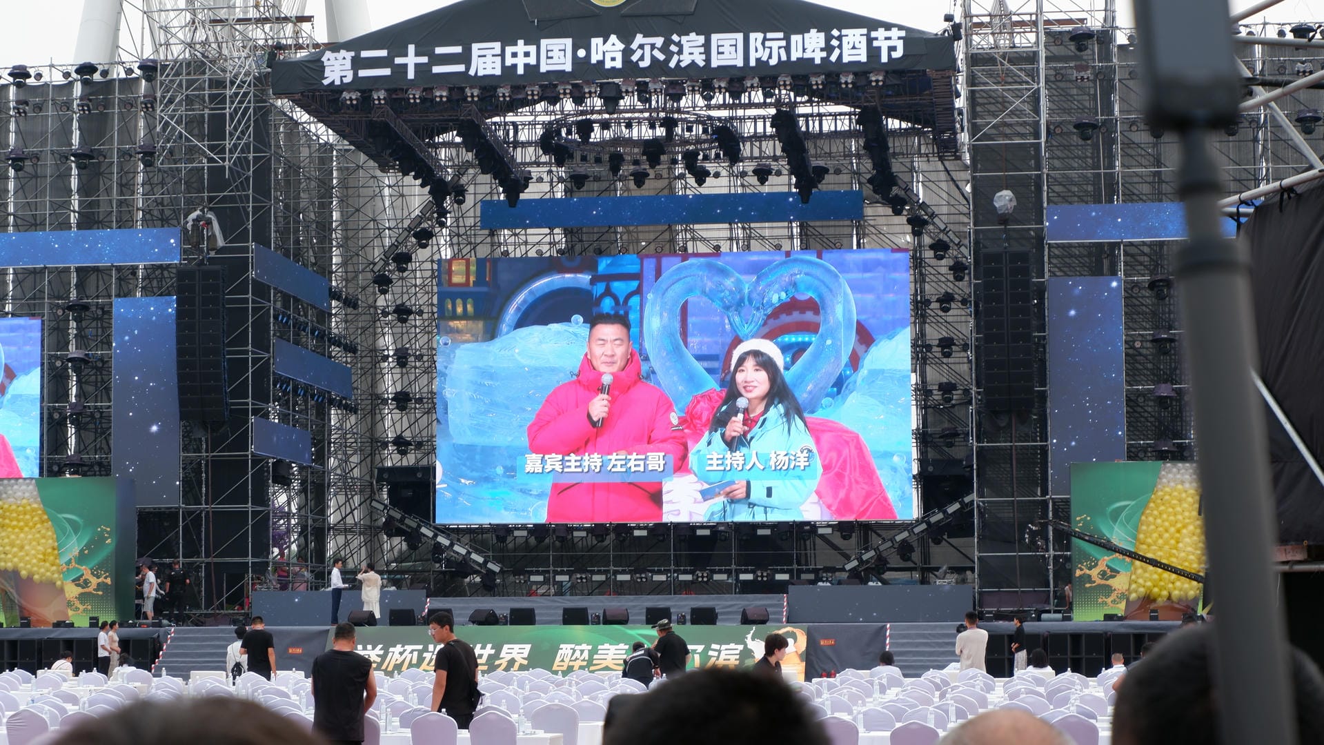 people are watching a large screen with a picture of a man and woman