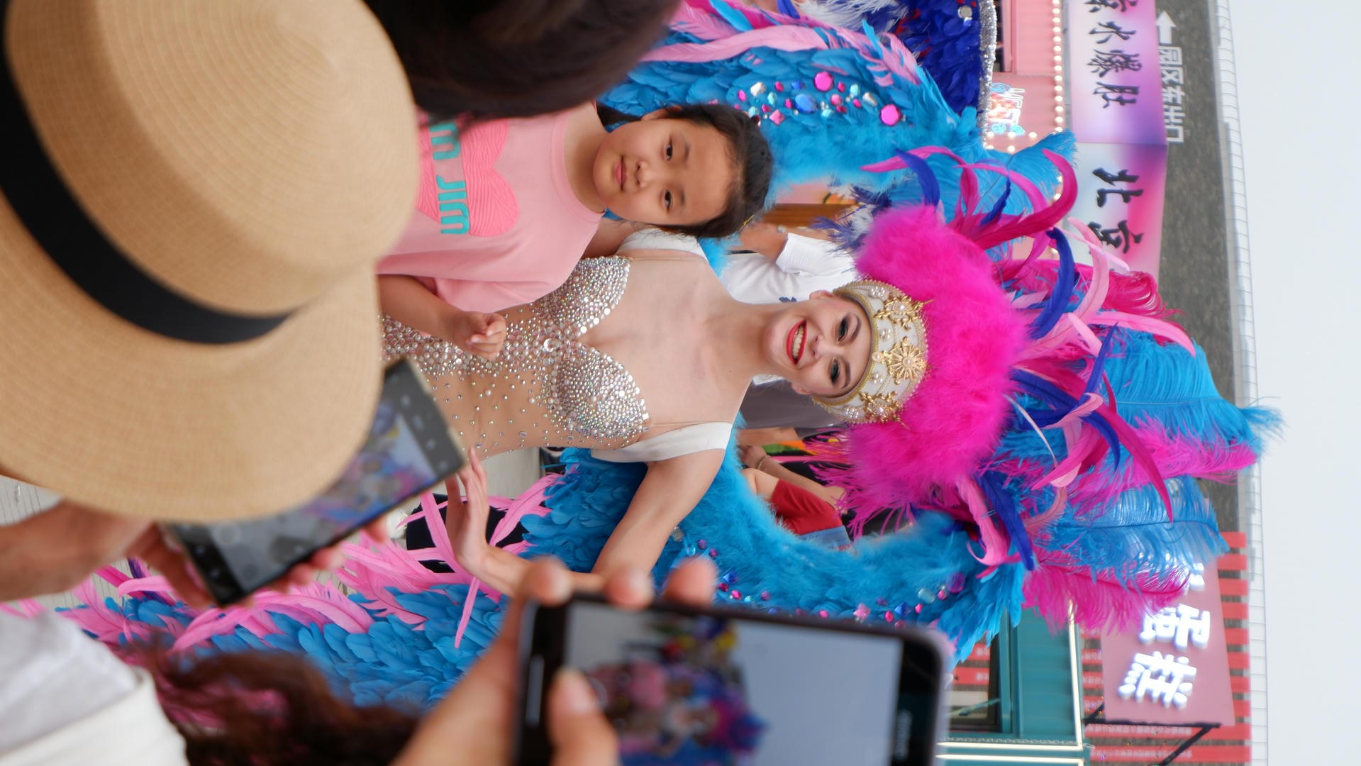 woman in a pink and blue costume taking a picture of a girl