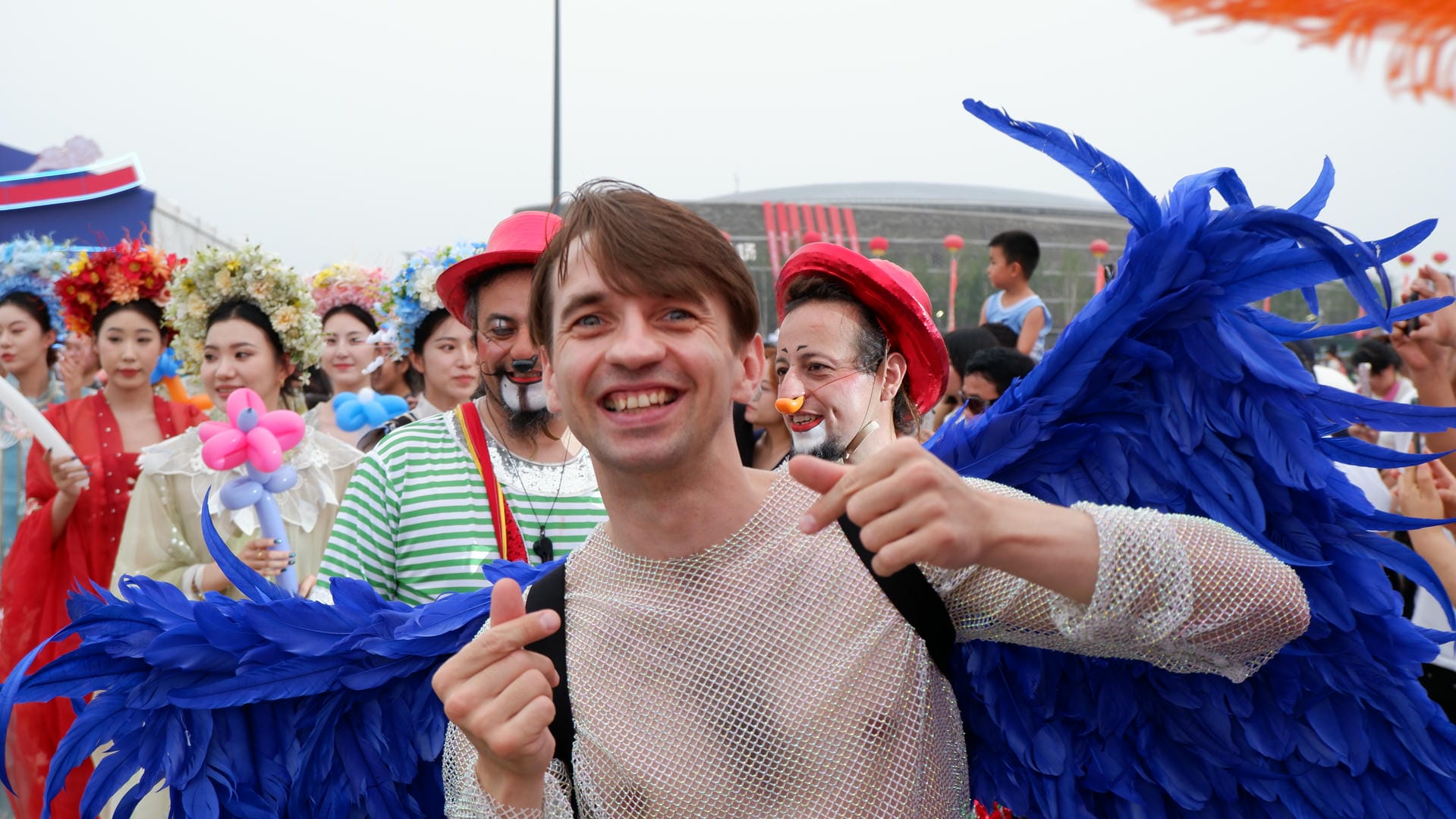 there is a man with a blue feathered costume on posing for a picture