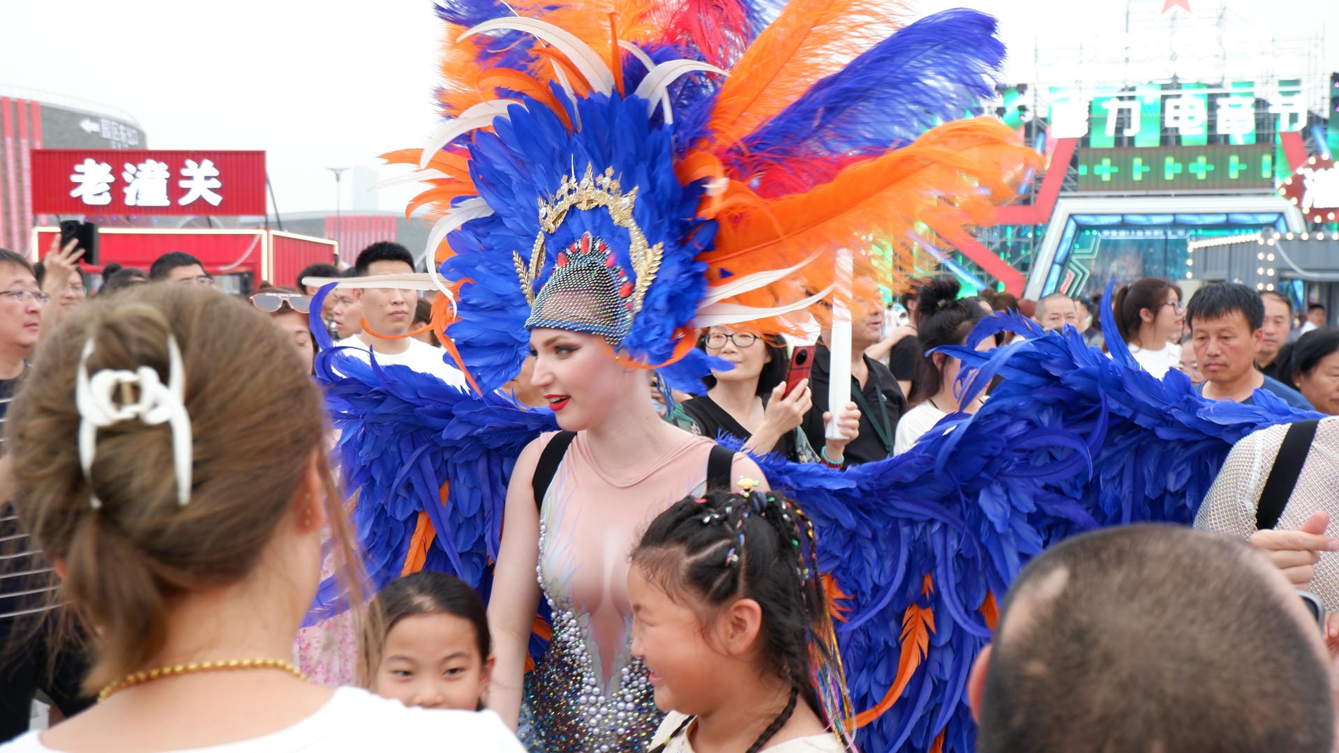there is a woman in a blue and orange costume standing in a crowd