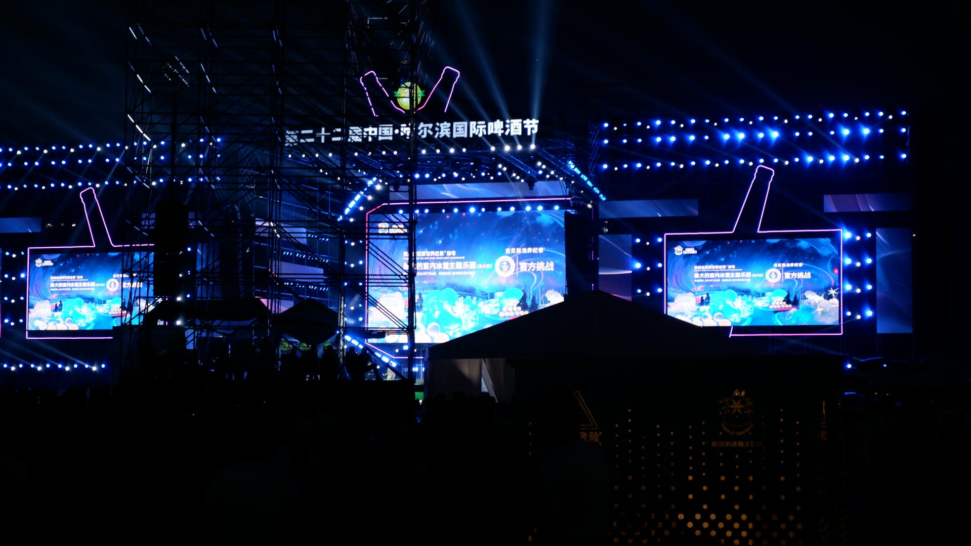 there are many people standing in front of a stage with lights