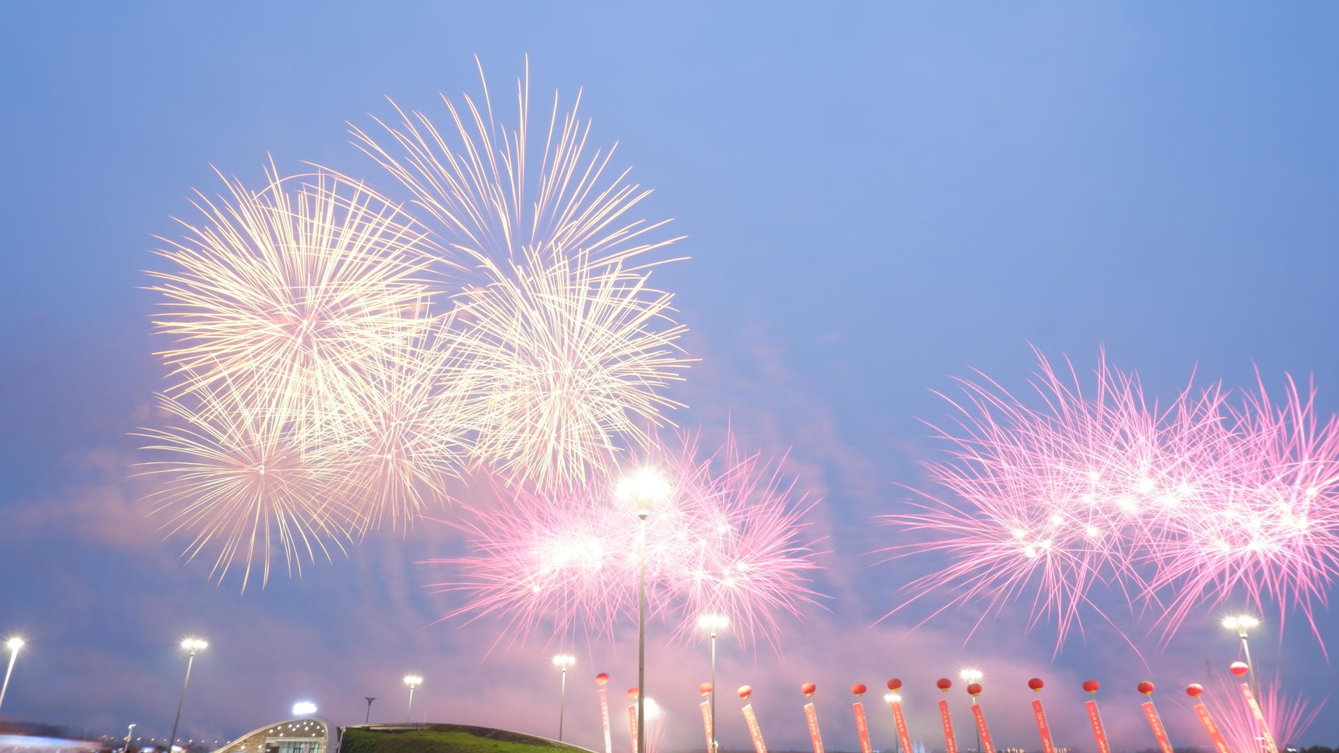 fireworks are lit up in the sky above a stadium with a crowd watching