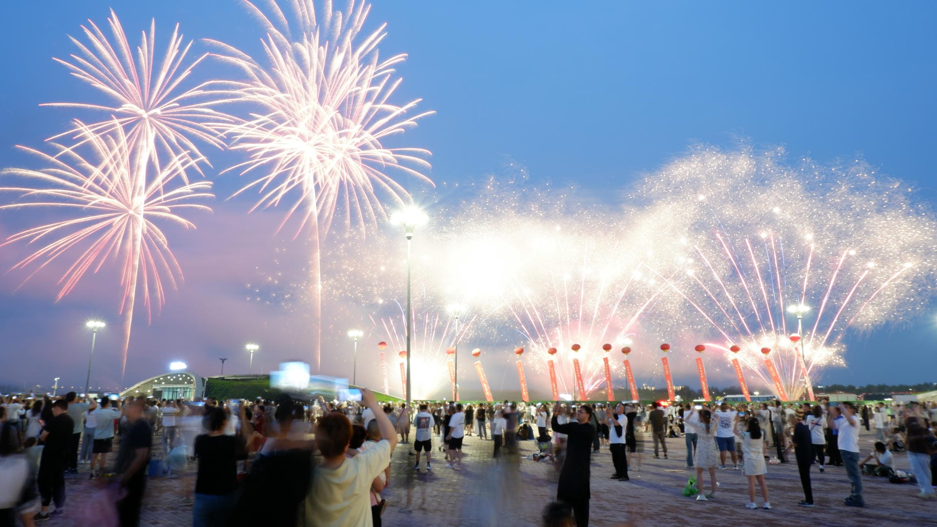 fireworks are lit up in the sky above a crowd of people
