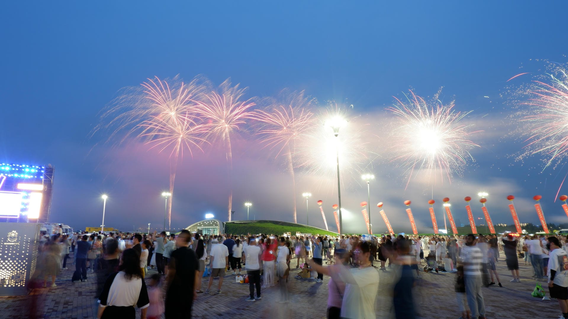 fireworks are lit up in the sky above a crowd of people