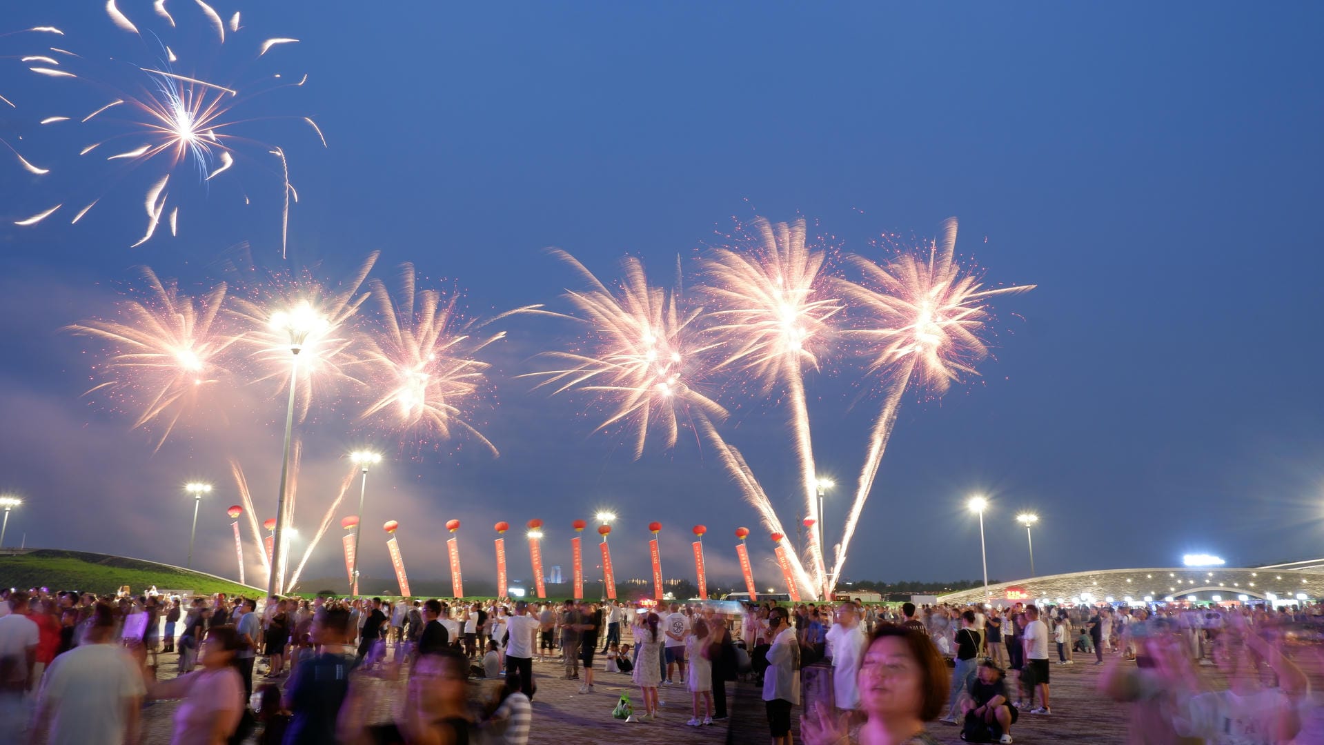 fireworks are lit up in the sky above a crowd of people