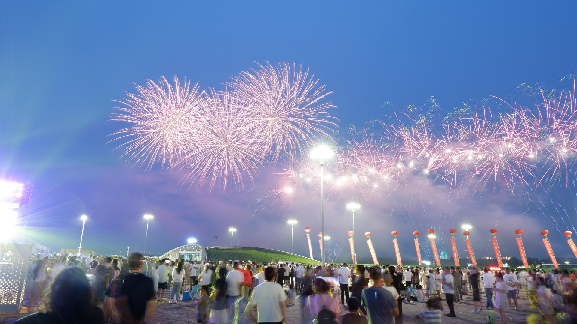 fireworks are lit up in the sky above a crowd of people