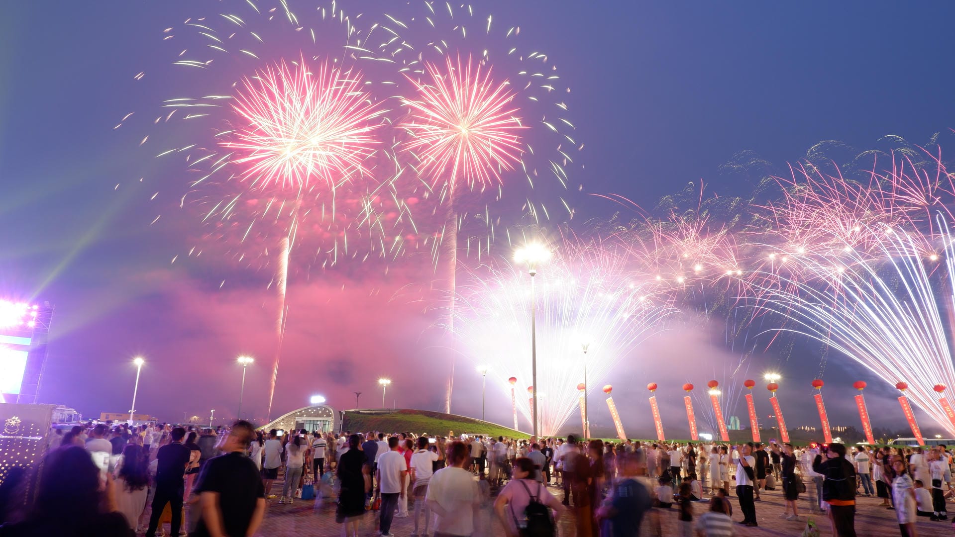 fireworks are lit up in the sky above a crowd of people