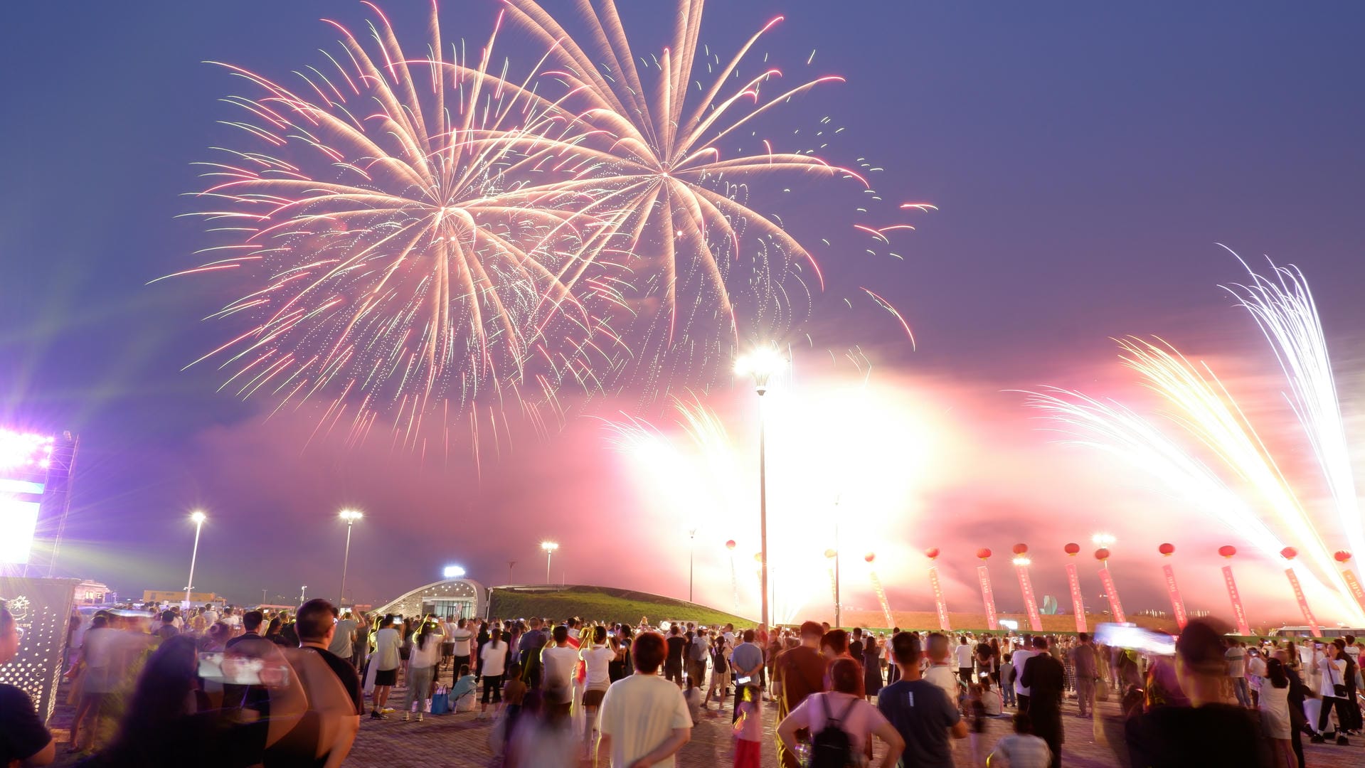 fireworks are lit up in the sky above a crowd of people