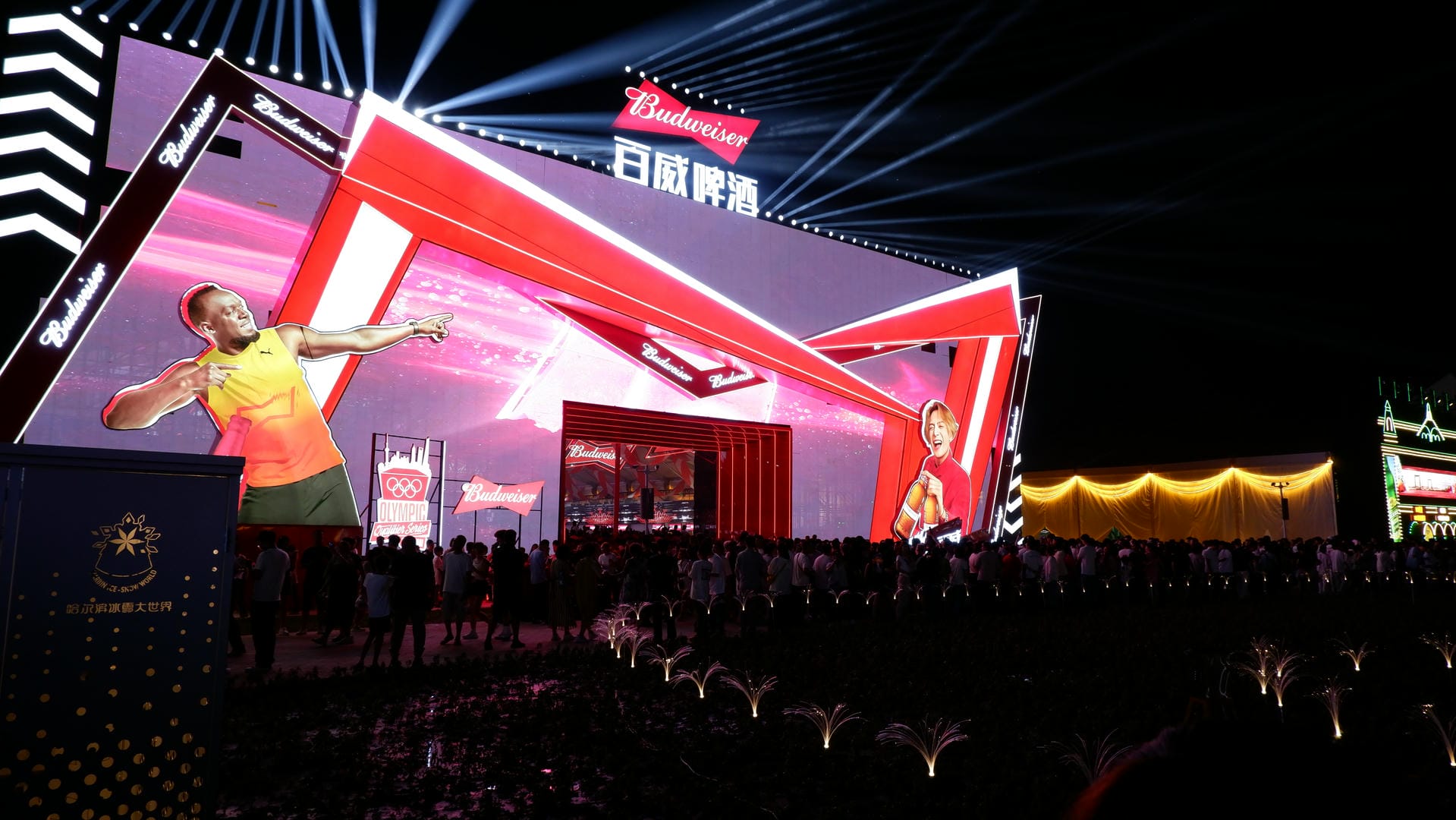 brightly lit stage with a man on a cell phone in front of a crowd