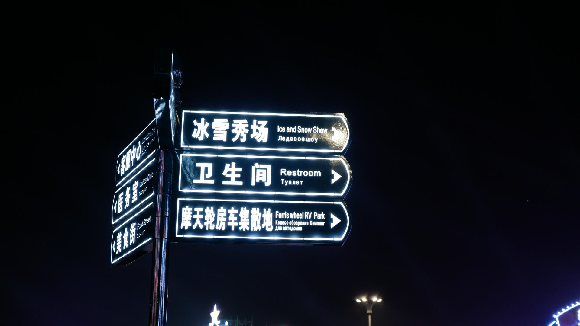 there are many street signs on a pole in the dark