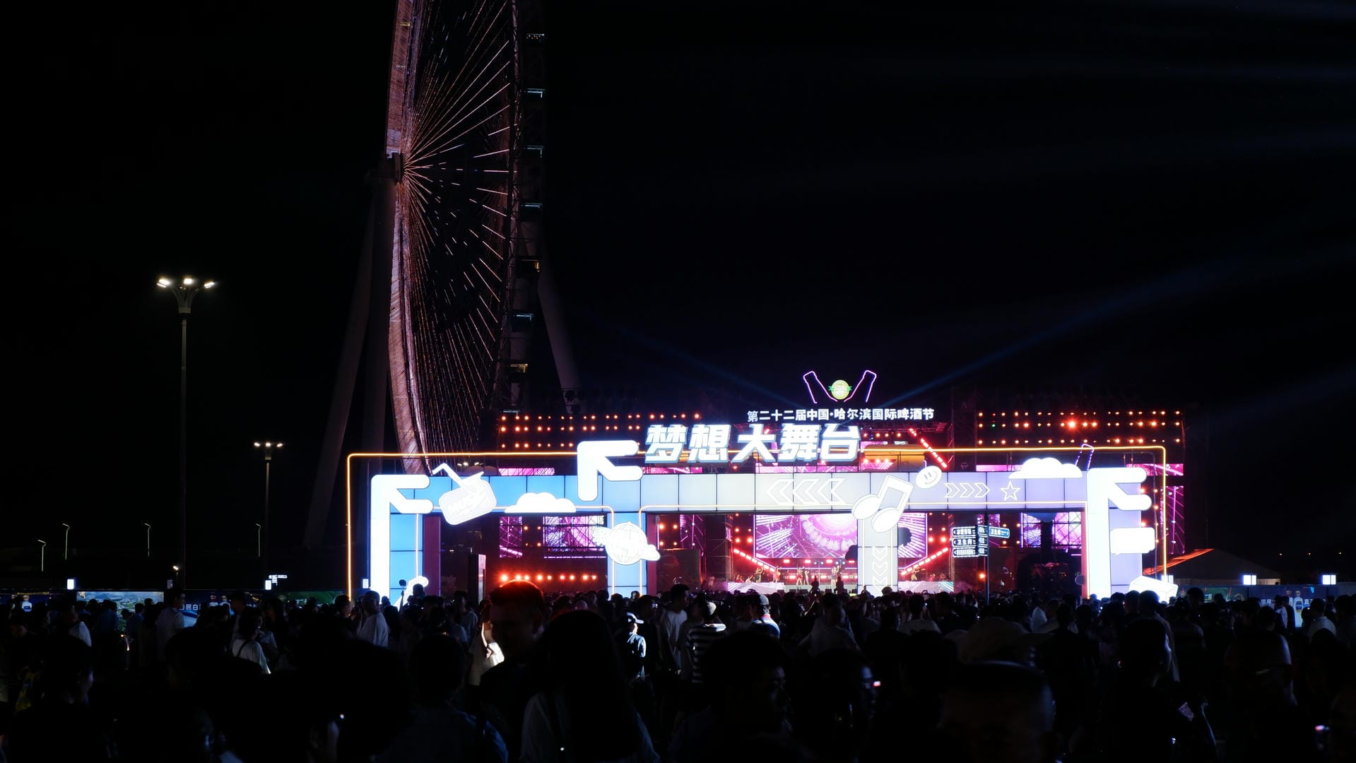 people are standing in front of a large screen with a ferris wheel in the background