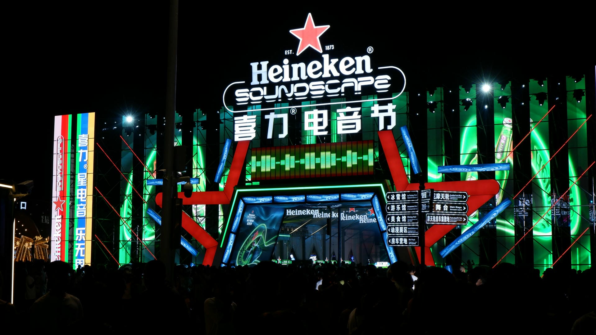 brightly lit building with neon signs and people in front of it