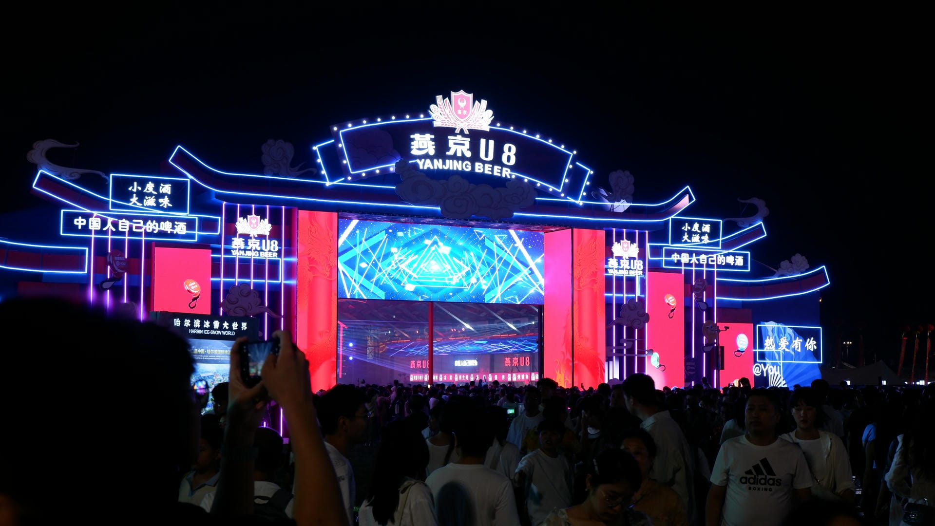 people are standing in front of a building with neon lights