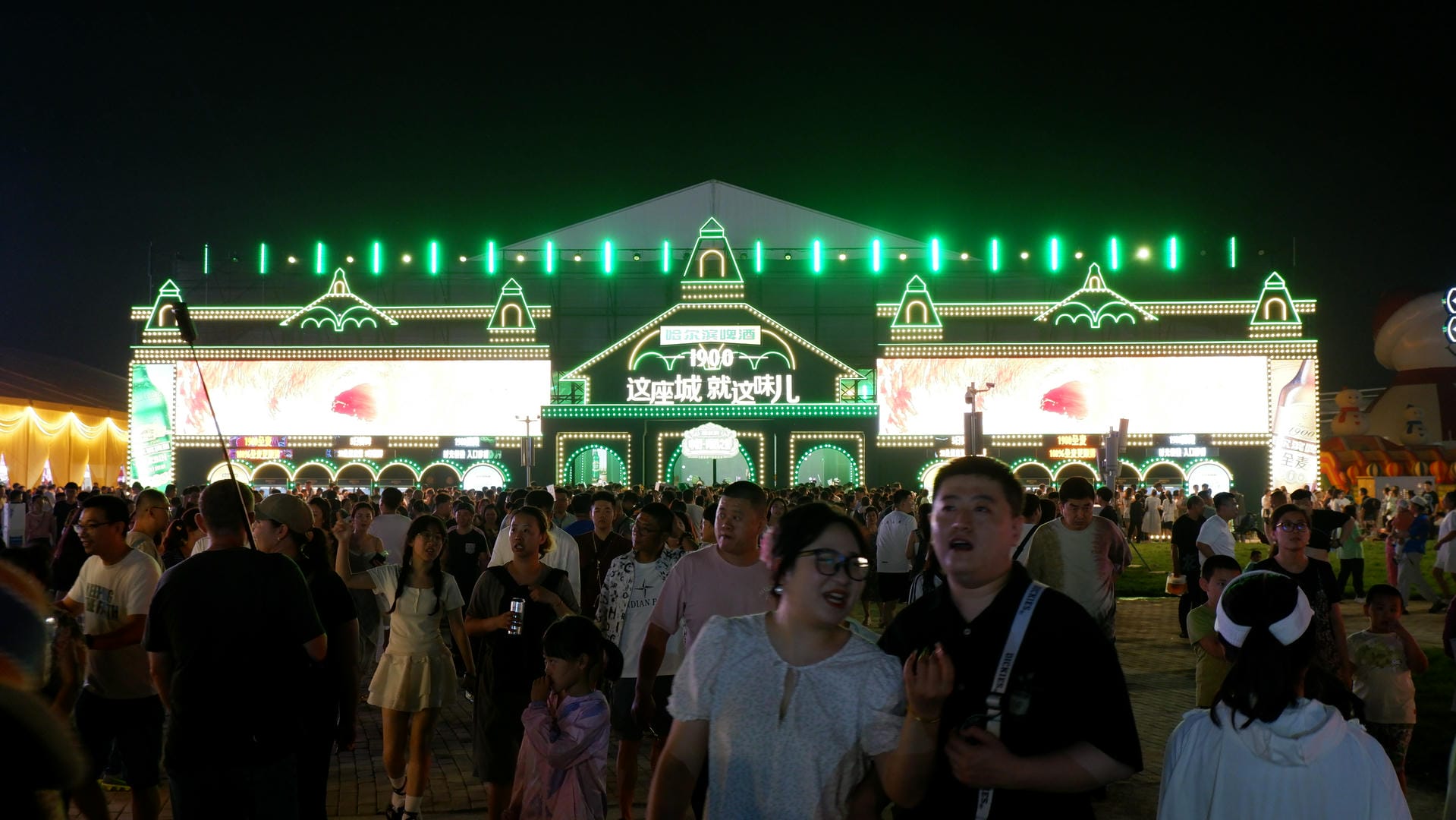 people are standing in front of a building with a green light