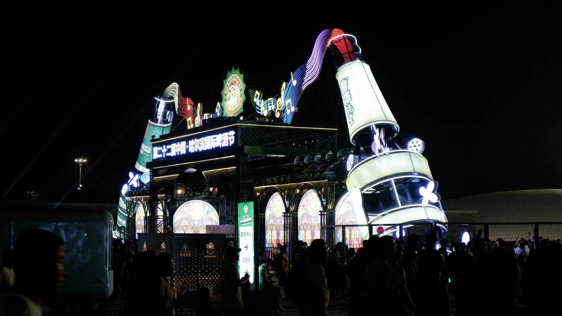 people are standing outside of a building with a lit up building